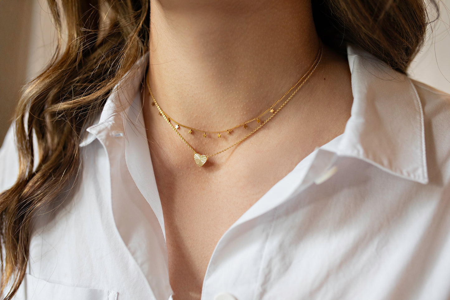 Gold star and heart necklace stack with white top