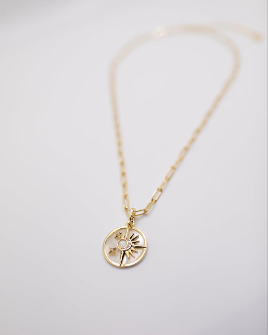 Gold Celestial necklace with a circular pendant on a light gray background
